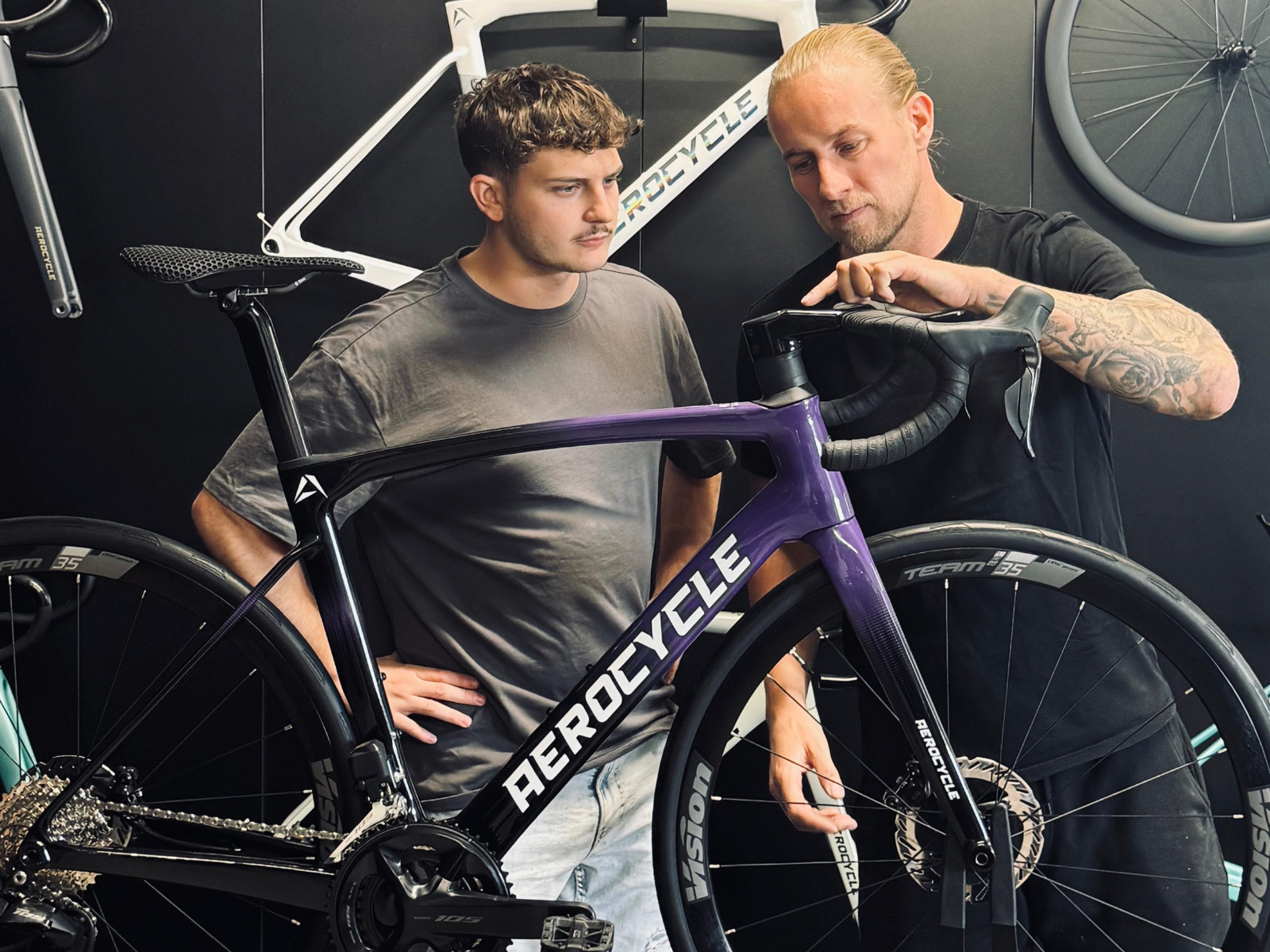 Aerocycle Beratung: Mechaniker erklärt einem Kunden sein Aerocycle Rennrad